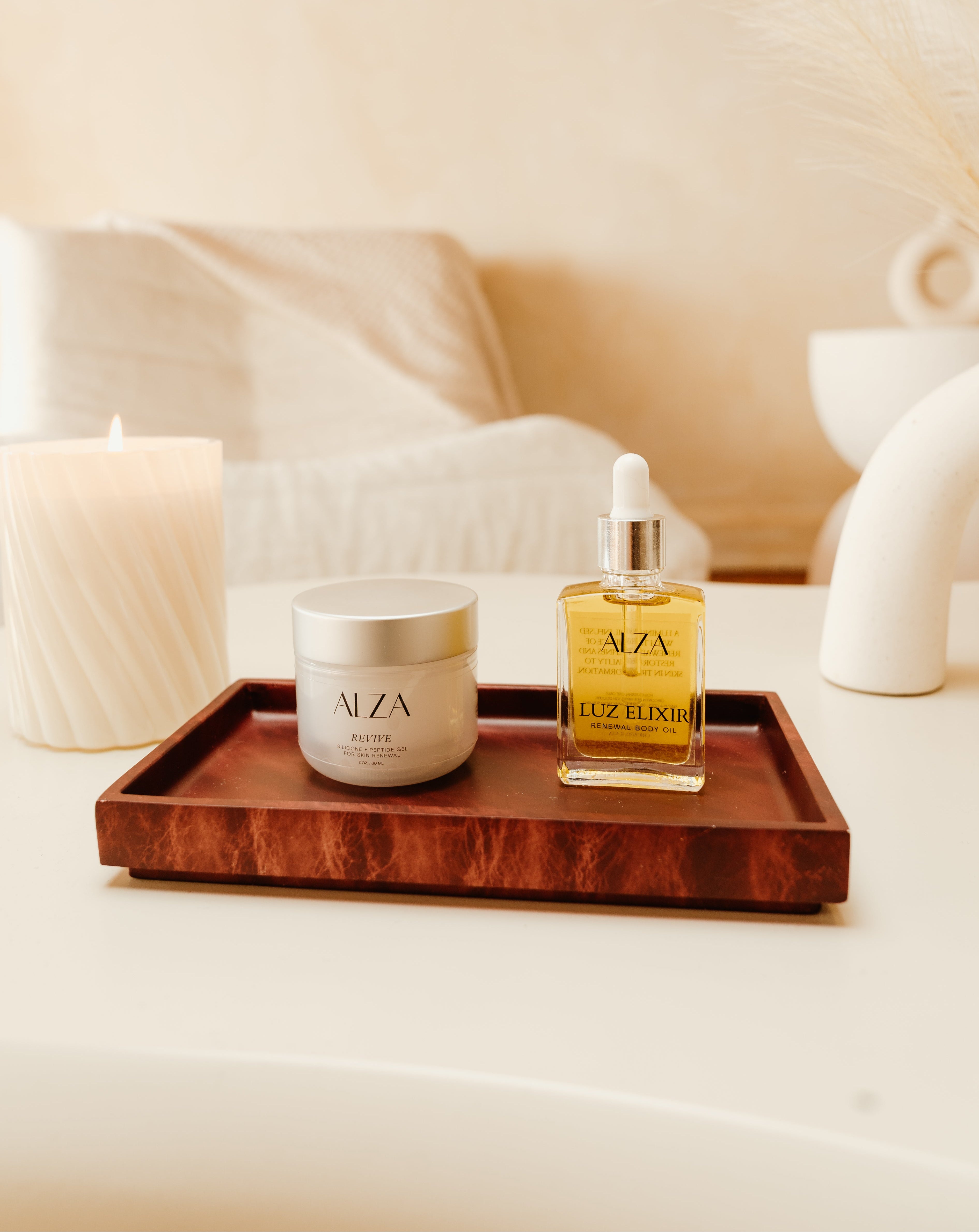 Tray with AIZA Scar Care products including a jar and oil bottle on a neutral background